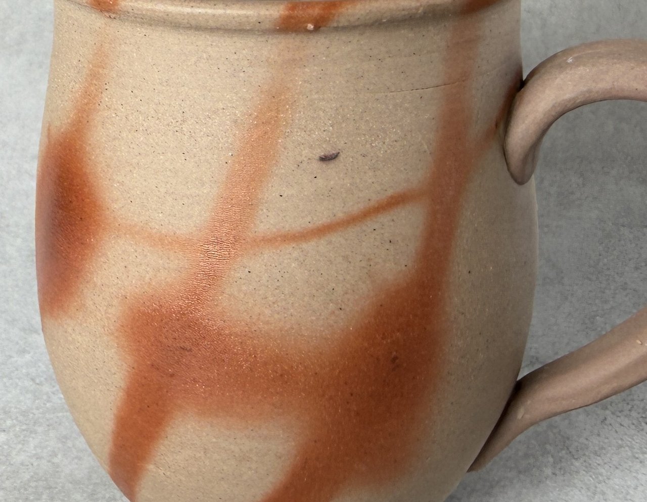 Bizen hidasuki firing pattern — scarlet and orange straw marks across pale clay