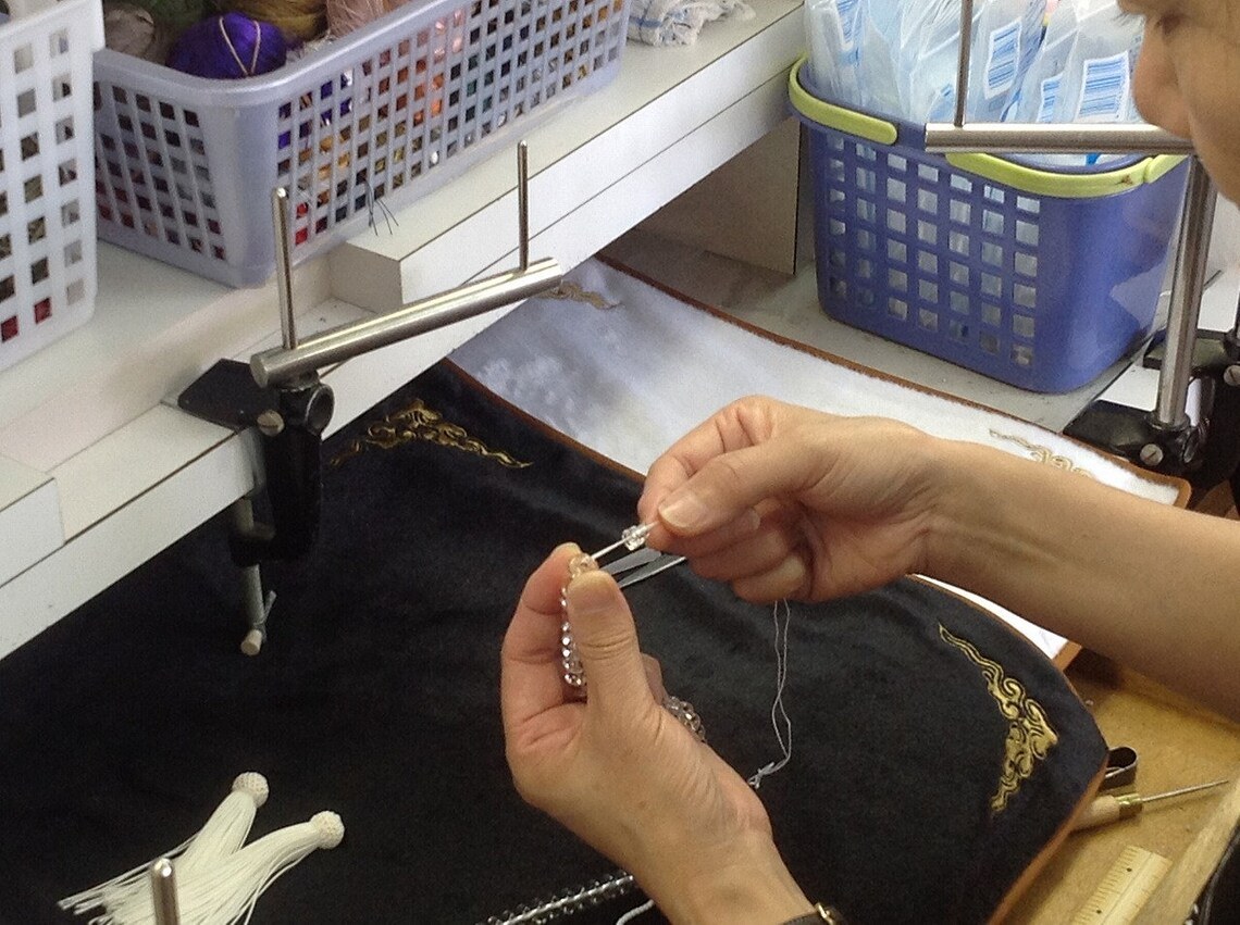 A juzu-maker's workbench with beads and a stringing jig