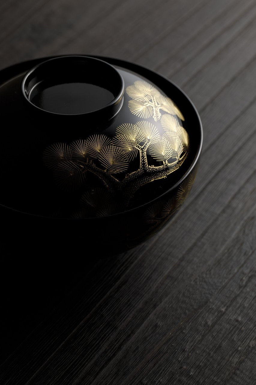 A black Wajima-nuri lidded bowl decorated with gold maki-e pine &mdash; an example of the finest, most labour-intensive traditional urushi tier