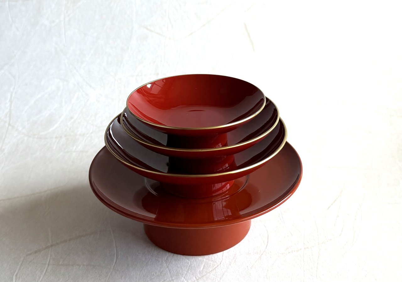 A black-lacquered sakazuki seen from above — the flat ceremonial cup whose depth of black is the result of many polished layers of natural urushi
