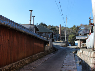 A quiet lane in the Shigaraki pottery district, kiln chimneys visible above the rooftops
