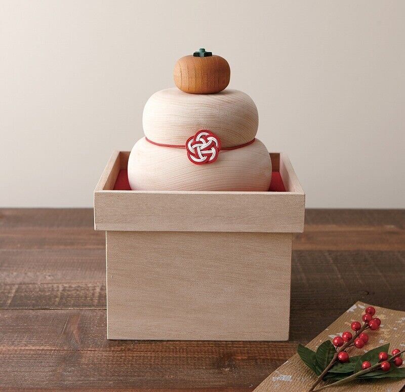 Handcrafted wooden kagami-mochi ornament displayed on a wooden masu box, made from Japanese cypress.